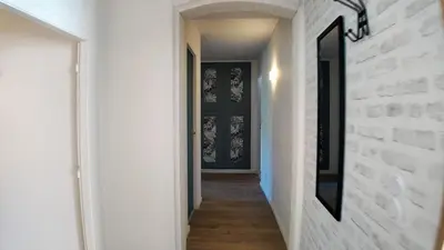 a hallway with a white brick wall and a black door at Elégant Appartement - 2 Chambres - Netflix - Terrasse in Castres