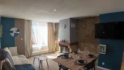 a living room with a wooden table and a fireplace at Elégant Appartement - 2 Chambres - Netflix - Terrasse in Castres