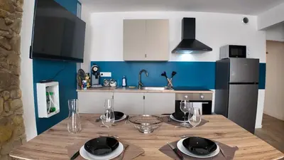 a kitchen with a wooden table with plates on it at Elégant Appartement - 2 Chambres - Netflix - Terrasse in Castres