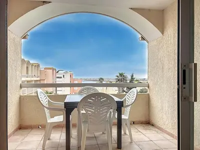 a table and chairs on a balcony with a view at Le Thalio - Swimming pool - Air conditioning in Gruissan