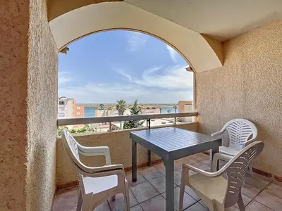 a patio with a table and chairs on a balcony at Le Thalio - Swimming pool - Air conditioning in Gruissan