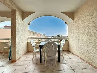 a table and chairs on a balcony with a view at Le Thalio - Swimming pool - Air conditioning in Gruissan
