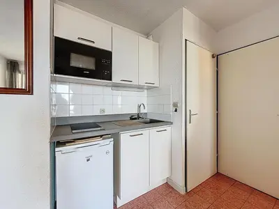 a kitchen with white cabinets and a sink at Le Thalio - Swimming pool - Air conditioning in Gruissan