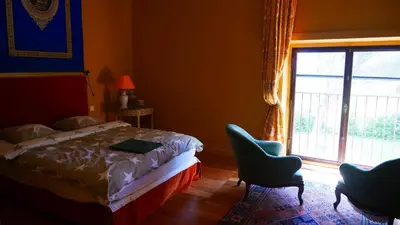 a bedroom with a bed and a window and two chairs at Maison Chérie Artisanal Farmhouse in Villarzel-du-Razès