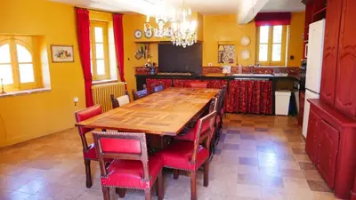 a kitchen with a wooden table and red chairs at Maison Chérie Artisanal Farmhouse in Villarzel-du-Razès