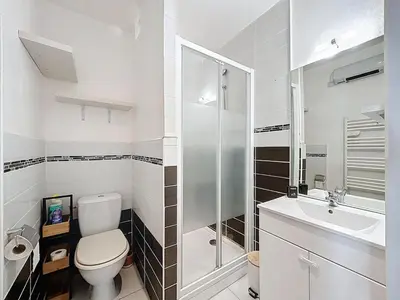 a white bathroom with a toilet and a sink at Le Bohja - Charming apartment near Les Halles in Narbonne