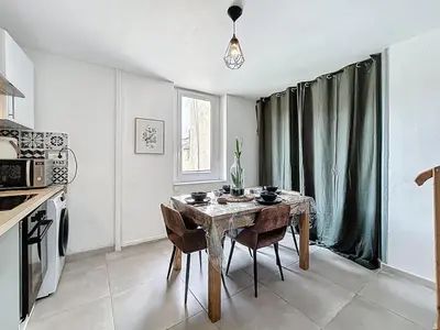a kitchen with a table and chairs in a room at Le Bohja - Charming apartment near Les Halles in Narbonne