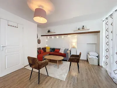 a living room with a red couch and a table at Le Bohja - Charming apartment near Les Halles in Narbonne