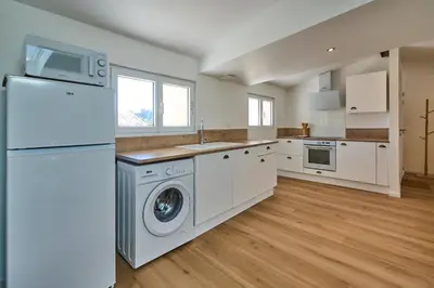 a kitchen with a refrigerator and a washer and dryer at Charme, confort en centre-ville in Limoux