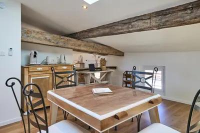 a dining room with a wooden table and chairs at Charme, confort en centre-ville in Limoux