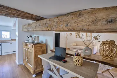 a kitchen with a table with a laptop on it at Charme, confort en centre-ville in Limoux