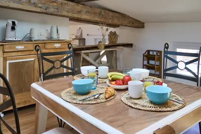 a wooden table with bowls of fruit on it at Charme, confort en centre-ville in Limoux