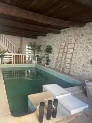 a swimming pool with two loungers in a house at Ô banc de la vigne in Fabrezan