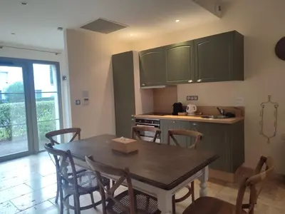 a kitchen with a table and chairs and a kitchen with green cabinets at La Redorte 24 in La Redorte