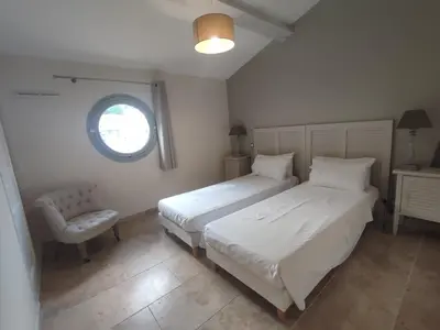 a bedroom with two beds and a chair and a window at La Redorte 24 in La Redorte