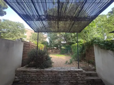 a pergola in a garden with a brick wall at La Redorte 24 in La Redorte
