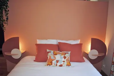 a bedroom with a bed with two lamps on it at L'Echiquier in Castres