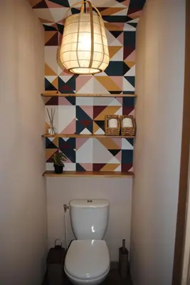a bathroom with a toilet and a colorful wall at L'Echiquier in Castres