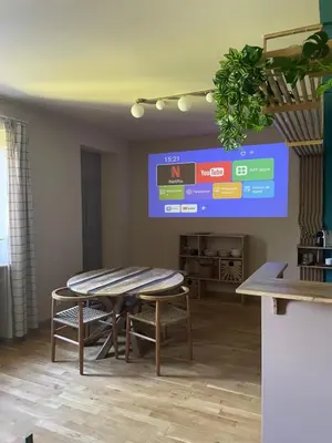 a dining room with a table and chairs and a large screen at L'Echiquier in Castres