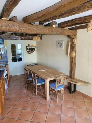 a kitchen with a wooden table and chairs at Gîte le Courdel in Les Brunels