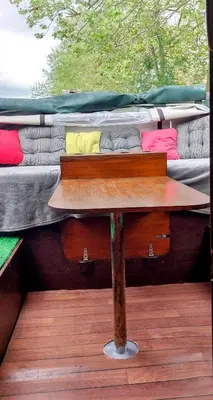 a table sitting on a deck with two beds at Studio bateau au Somail in Saint-Nazaire-dʼAude