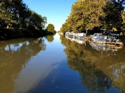 a river with boats docked on the side of it at Studio bateau au Somail in Saint-Nazaire-dʼAude