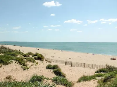 a beach with people on it and the ocean at Studio bateau au Somail in Saint-Nazaire-dʼAude