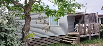 a tiny house with a porch and a tree at El sol in Port-la-Nouvelle