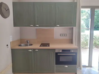 a kitchen with green cabinets and a sink at La Redorte 29 in La Redorte