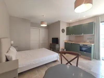 a bedroom with a bed and a kitchen with green cabinets at La Redorte 29 in La Redorte