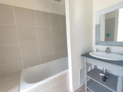 a bathroom with a sink and a tub and a mirror at La Redorte 29 in La Redorte