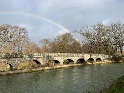 a rainbow over a stone bridge over a river at La Redorte 29 in La Redorte