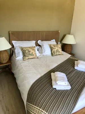 a large bed with two lamps and towels on it at La Maison de l'Aqueduc - 4 pers au cœur des vignes - in Cournanel