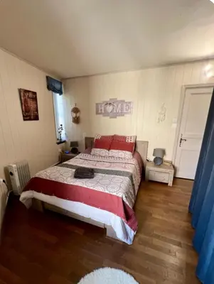 a bedroom with a large bed with red pillows at Bienvenue chez Sandrine in La Redorte