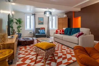 a living room with a couch and a table at Le Baron terrasse et parking cœur de Castres in Castres