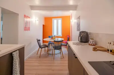 a kitchen with a table and chairs in a room at Le Baron terrasse et parking cœur de Castres in Castres
