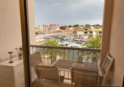 a balcony with a table and chairs and a view of a city at Ciel & Sel in Gruissan