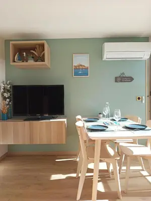 a dining room with a table and a television at Ciel & Sel in Gruissan
