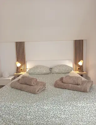 a bedroom with two towels on a bed with two lamps at Ciel & Sel in Gruissan