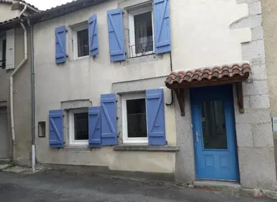 a building with blue shuttered windows and a blue door at Sidobre in Lacrouzette