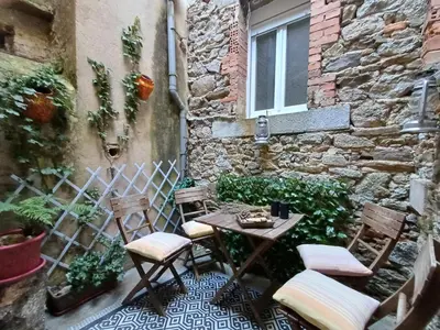 a patio with chairs and a table in front of a building at Sidobre in Lacrouzette