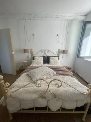 a bedroom with a large bed with a white bedspread at Large charming house surrounded by nature in Brassac