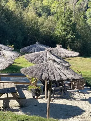 a group ofiki umbrellas and picnic tables and benches at Large charming house surrounded by nature in Brassac