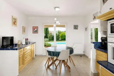 a kitchen with a table and chairs in a kitchen at Villa La Cavayere swimming pool air conditioning in Carcassonne
