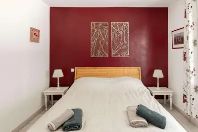 a bedroom with a large bed with two tables at Villa La Cavayere swimming pool air conditioning in Carcassonne