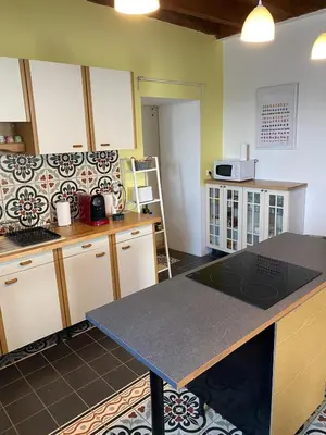 a kitchen with a table and a counter top at La maison Pont Rouge in Carcassonne