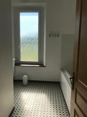 a bathroom with a window and a tiled floor at La maison Pont Rouge in Carcassonne
