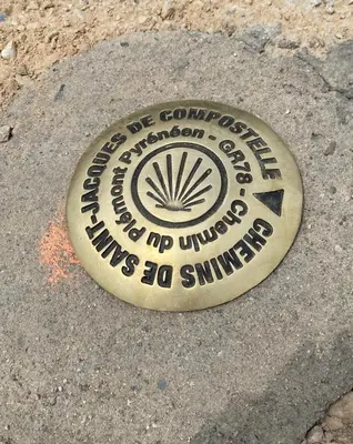 a metal sign on the ground in the street at La maison Pont Rouge in Carcassonne