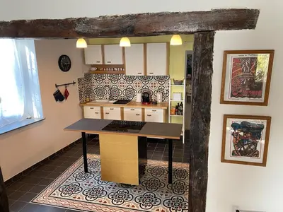 a kitchen with a table in the middle of a room at La maison Pont Rouge in Carcassonne