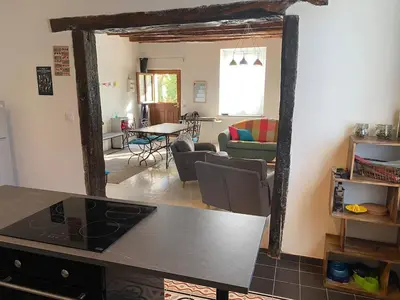a kitchen and living room with a table in a room at La maison Pont Rouge in Carcassonne